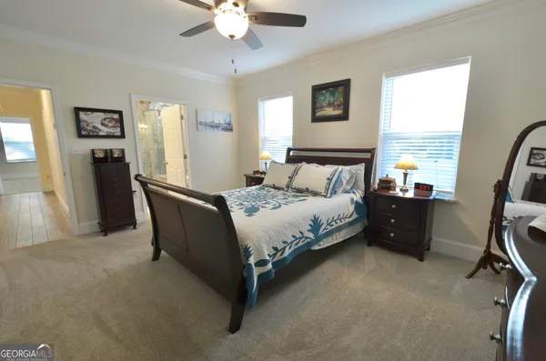 a spacious bedroom with a bed and a chandelier