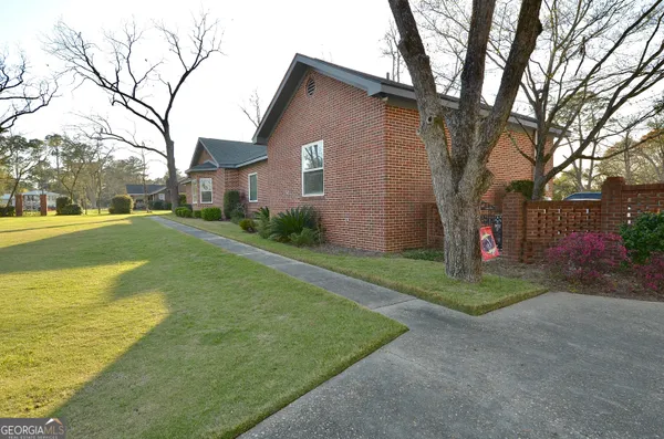 a view of a house with backyard and sitting area