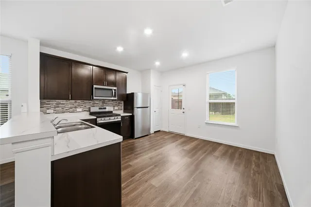 a kitchen with stainless steel appliances granite countertop a sink stove and refrigerator