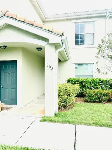 a view of a small house with potted plants