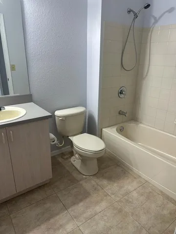 a bathroom with a granite countertop toilet a sink and bathtub