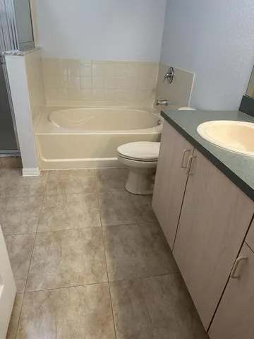 a bathroom with a sink a toilet a mirror and shower