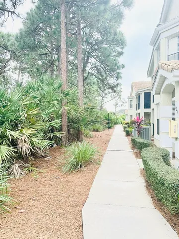 a front view of a house with a yard and fountain in middle