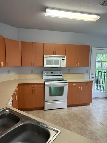 a kitchen with granite countertop a stove a sink and a microwave