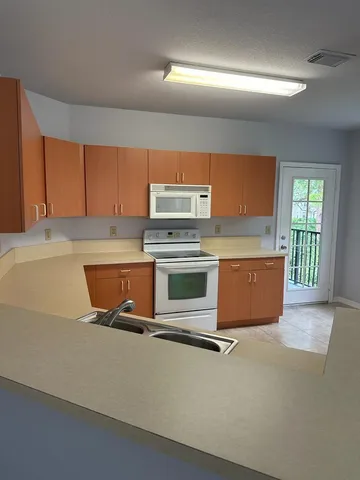 a kitchen with kitchen island granite countertop wooden cabinets and a stove