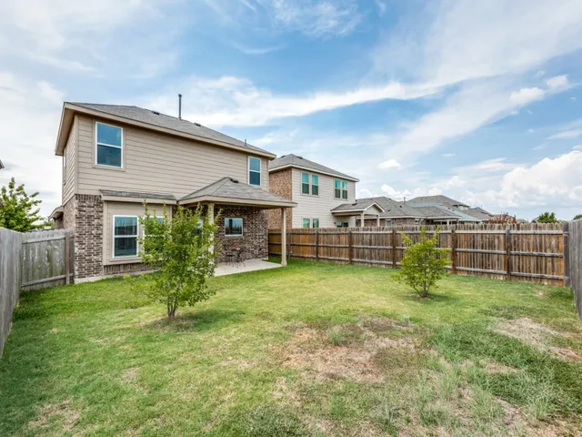 a view of a house with a yard and sitting area