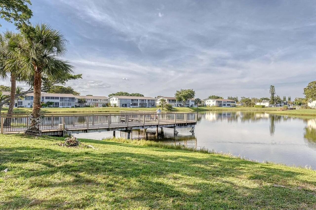 128 Canterbury F, Unit 128 West Palm Beach, FL 33417 - Photo 15 of 17 a view of a lake with a big yard