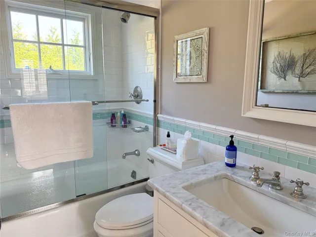 a bathroom with a sink toilet and window