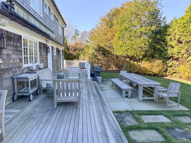 a view of a patio with table and chairs with wooden floor and fence
