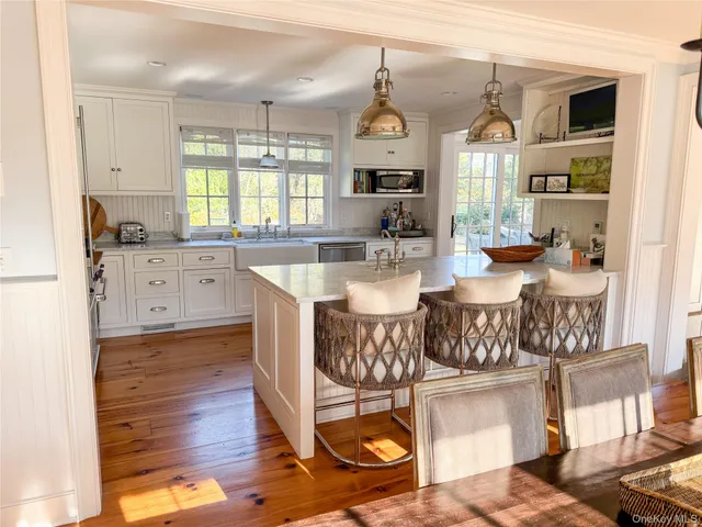 a open kitchen with granite countertop a stove and white cabinets