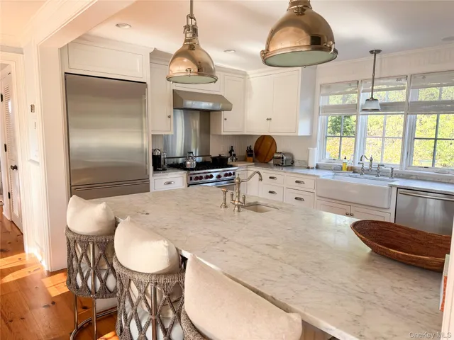 a kitchen with stainless steel appliances granite countertop a sink a stove and a refrigerator