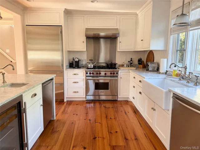 a kitchen with cabinets appliances and a wooden floor