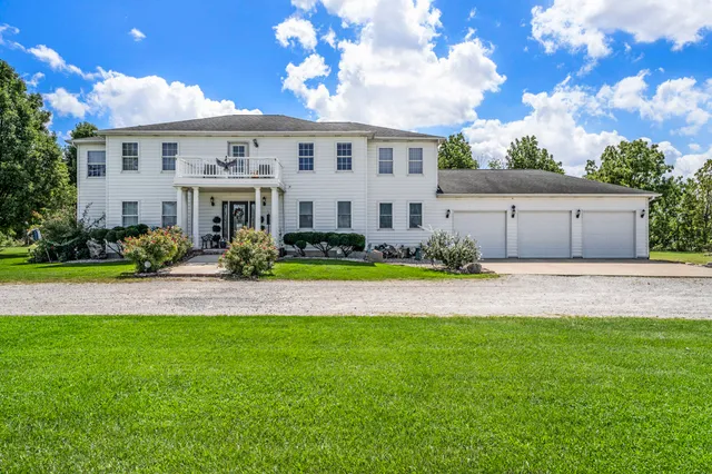 a front view of a house with a garden and plants