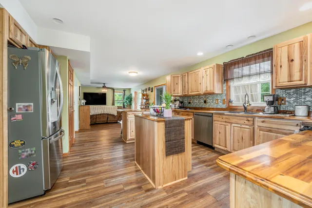 a kitchen with stainless steel appliances granite countertop a refrigerator sink and cabinets