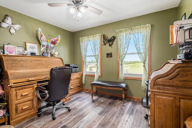 a view of a workspace with furniture and a window