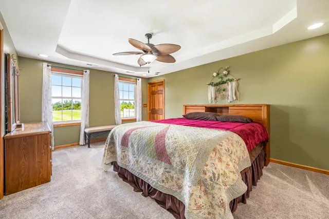 a bed sitting in a bedroom next to a window and a chandelier