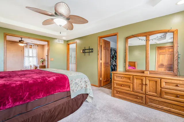 a bedroom with a large bed and a chandelier