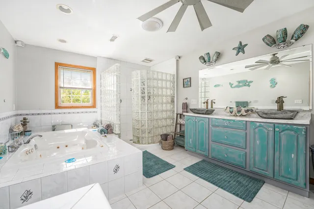 a spacious bathroom with a double vanity sink mirror and bathtub