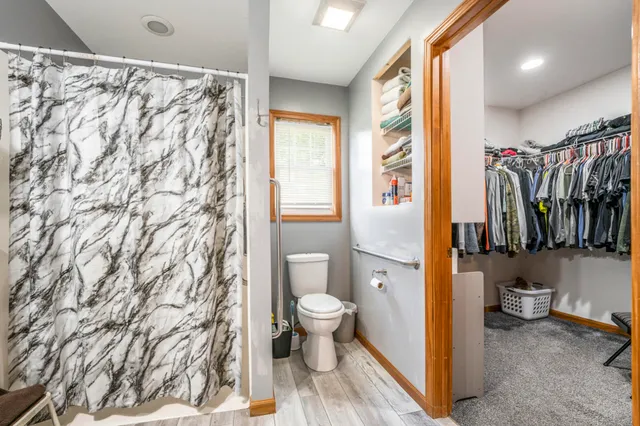 a bathroom with a toilet and a shower curtain