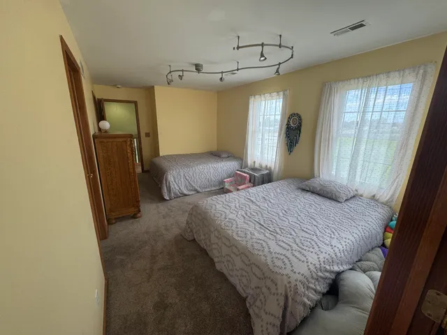 a bedroom with a bed window and walk in closet