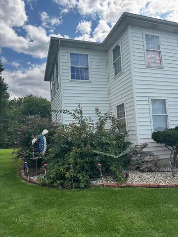 a front view of a house with a garden and plants