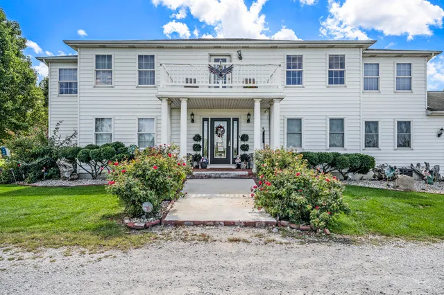 a front view of a house with a garden and plants