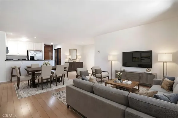 a living room with furniture kitchen view and a flat screen tv