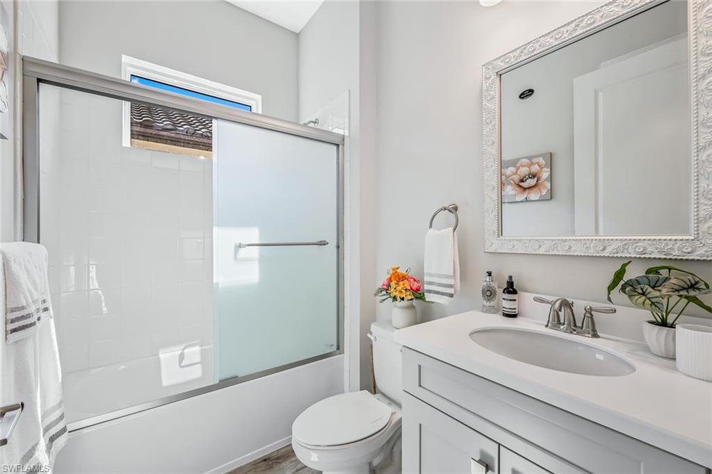 15495 Rio Ponace Court Naples, FL 34114 - Photo 18 of 43 Bathroom with vanity and shower / bath combination with glass door