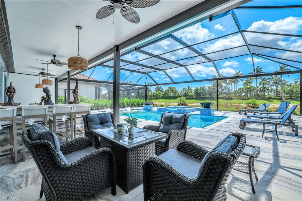 15495 Rio Ponace Court Naples, FL 34114 - Photo 25 of 43 View of patio / terrace featuring ceiling fan, a pool with connected hot tub, and a lanai