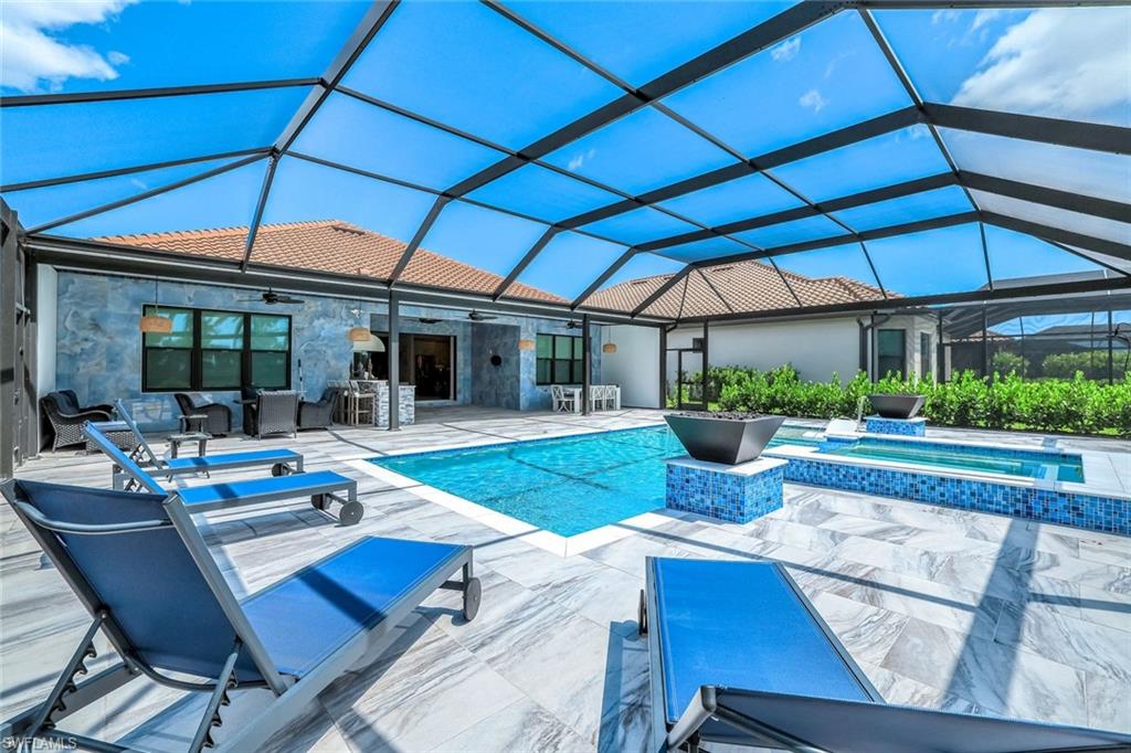 15495 Rio Ponace Court Naples, FL 34114 - Photo 30 of 43 View of pool with ceiling fan, a patio, a pool with connected hot tub, an outdoor living space, and glass enclosure