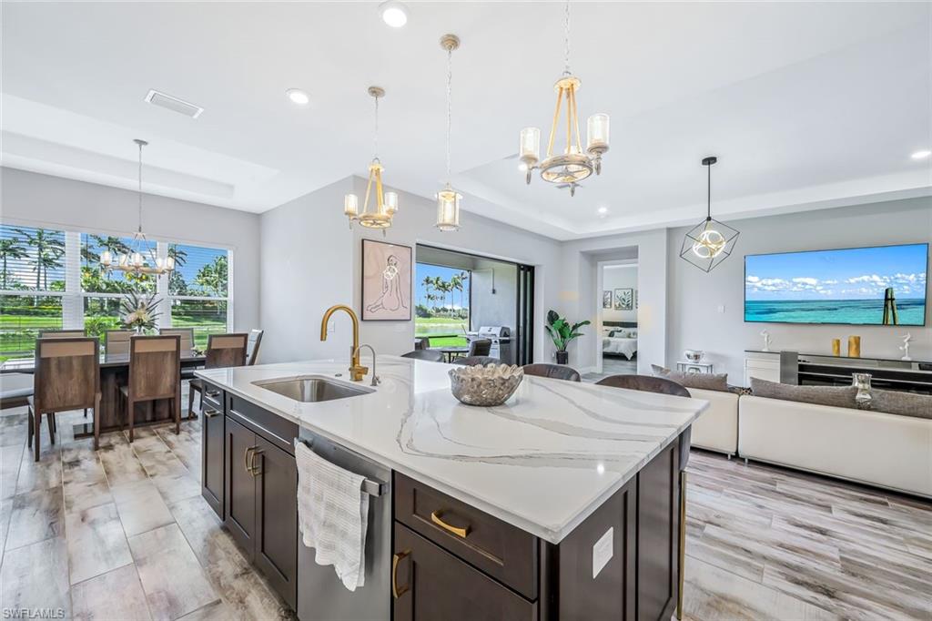 15495 Rio Ponace Court Naples, FL 34114 - Photo 43 of 43 Kitchen featuring a chandelier, stainless steel dishwasher, a raised ceiling, open floor plan, and recessed lighting