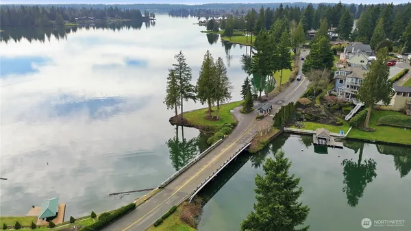 a view of a swimming pool with a yard and large tree