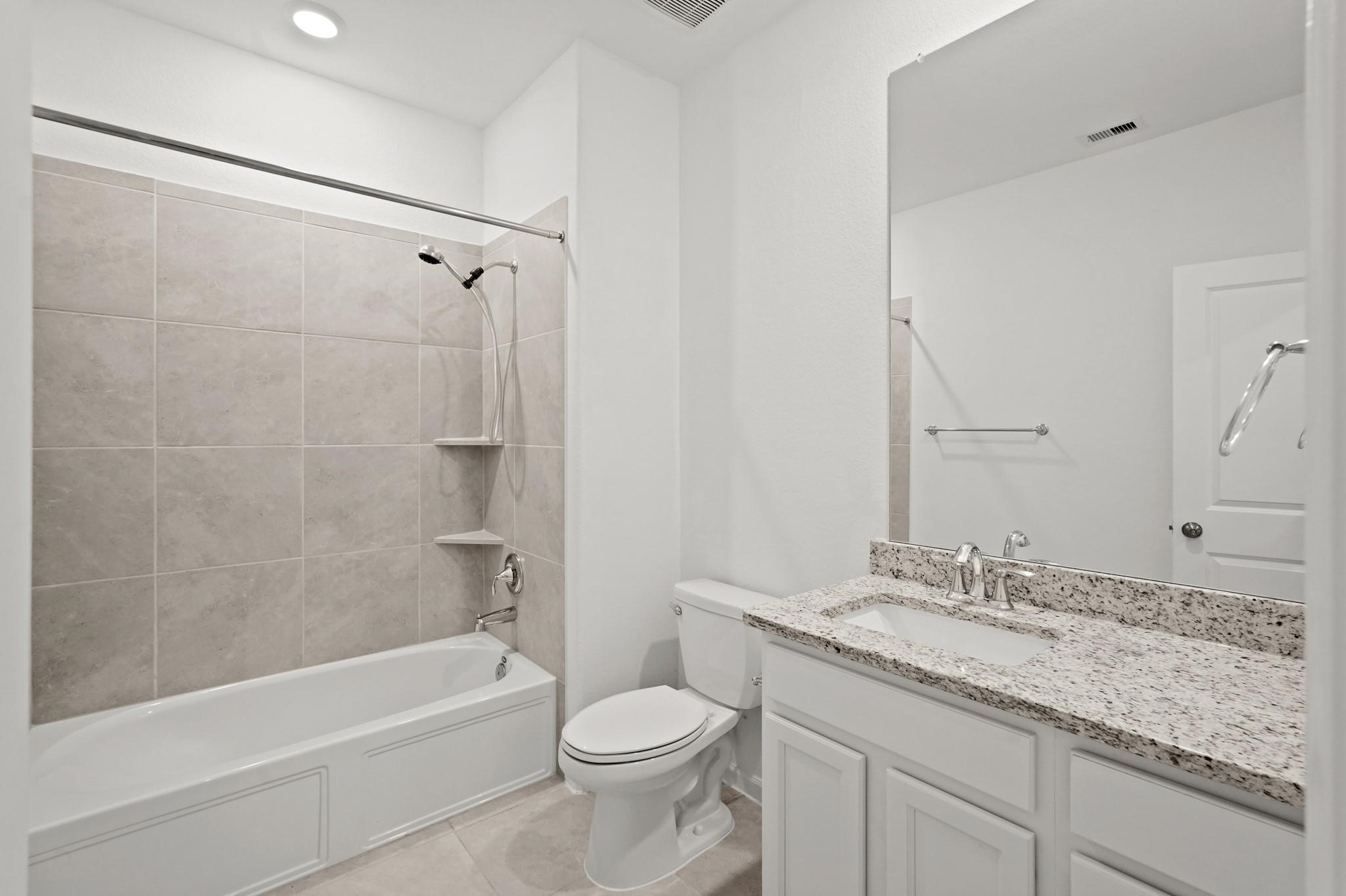 4915 Sierra Ridge Drive Rosenberg, TX 77469 - Photo 18 of 25 a bathroom with a granite countertop sink a toilet and bathtub