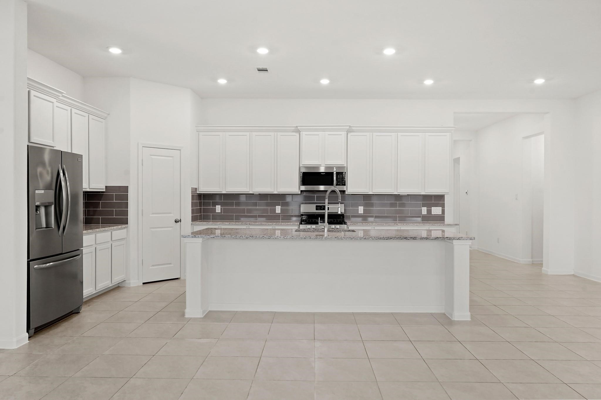 4915 Sierra Ridge Drive Rosenberg, TX 77469 - Photo 3 of 25 a kitchen with stainless steel appliances granite countertop a refrigerator a sink and white cabinets