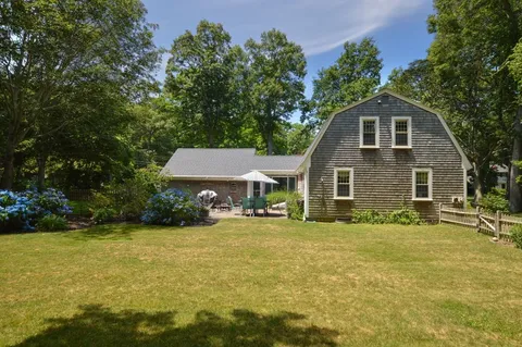 a front view of a house with a yard and trees