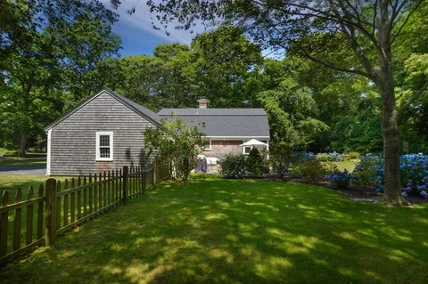 a front view of a house with yard and green space