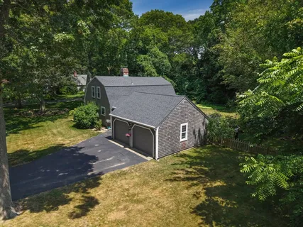 a aerial view of a house with a yard and large tree