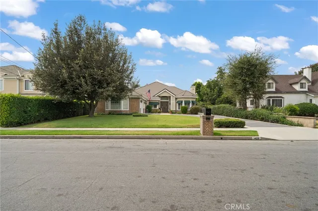 a view of big house with a big yard and potted plants