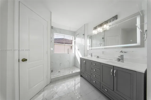 a bathroom with a double vanity sink mirror and shower