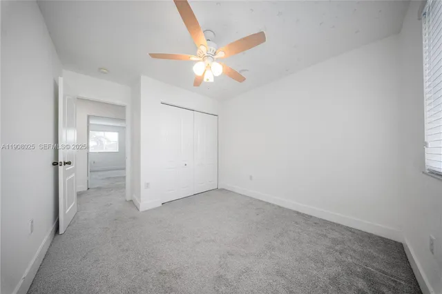 an empty room with closet and a chandelier fan