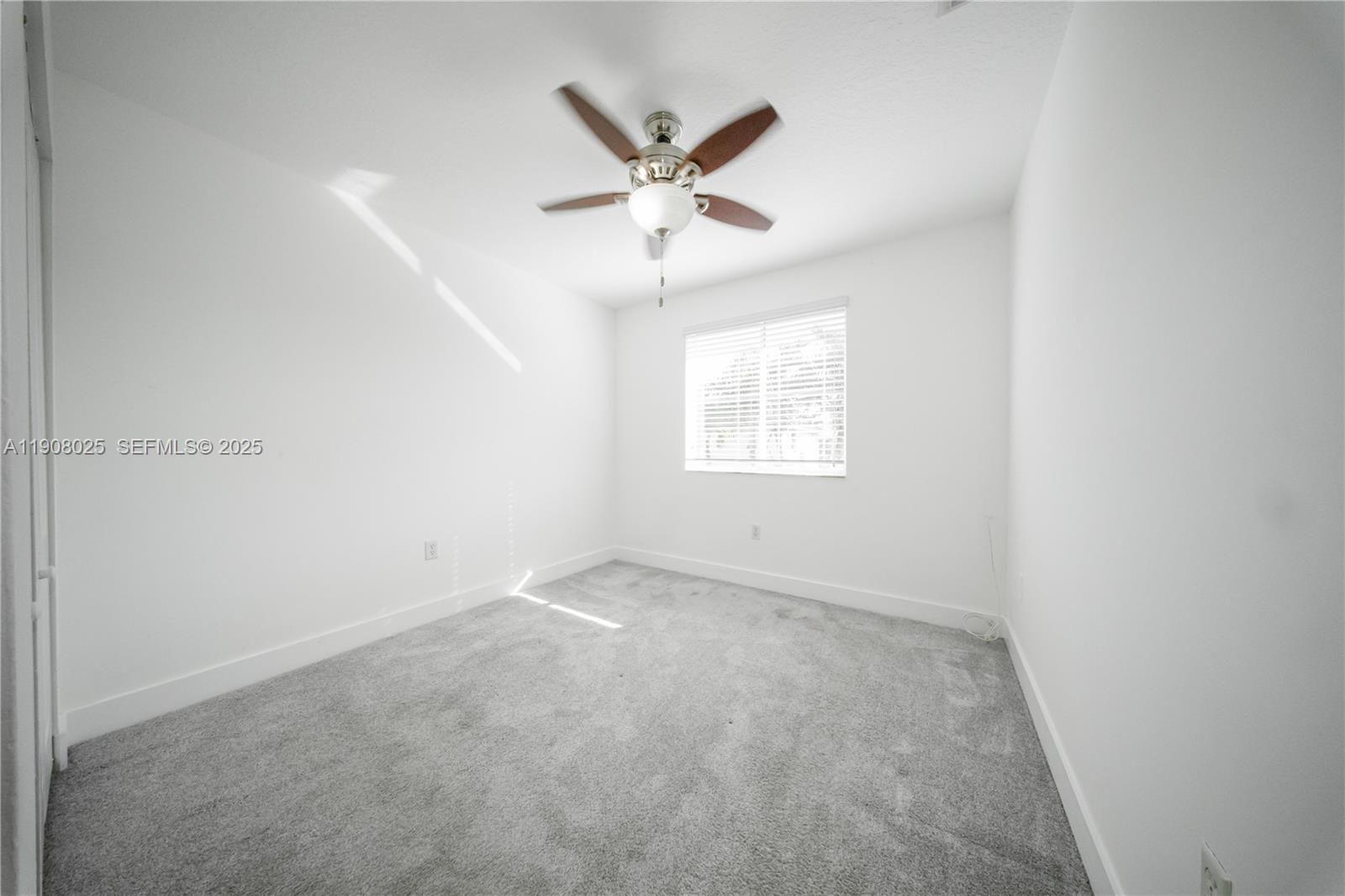 13868 Southwest 38th Terrace Miami, FL 33175 - Photo 22 of 30 an empty room with a ceiling fan and windows