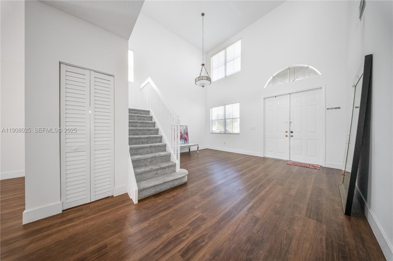 13868 Southwest 38th Terrace Miami, FL 33175 - Photo 4 of 30 an empty room with wooden floor staircase and windows