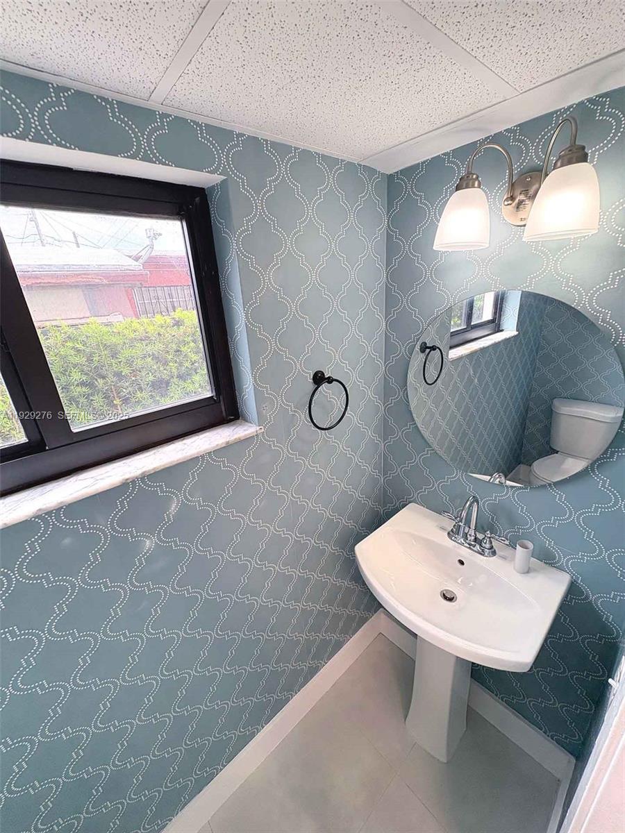 3079 Northwest 11th Street, Unit 3053 Miami, FL 33125 - Photo 6 of 11 a bathroom with a sink and a mirror