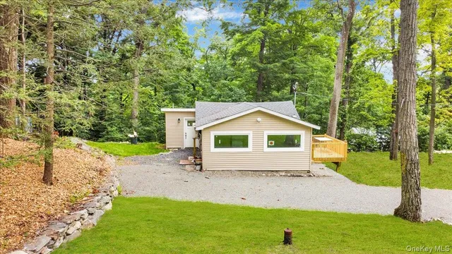 a view of a yard in front of a house with large trees