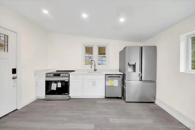 a kitchen with stainless steel appliances a refrigerator sink and stove