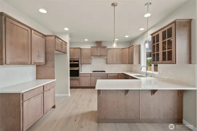 a large kitchen with kitchen island a sink stainless steel appliances and cabinets