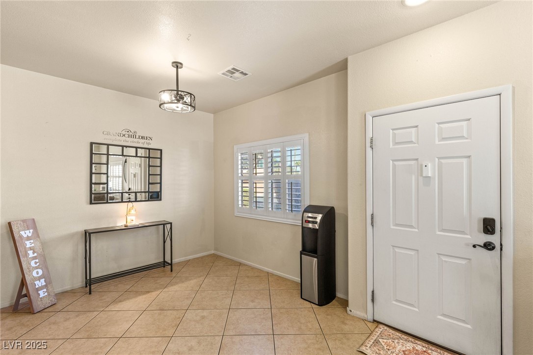 1591 Rusty Ridge Lane Henderson, NV 89002 - Photo 11 of 27 Entrance foyer featuring light tile patterned floors and a chandelier