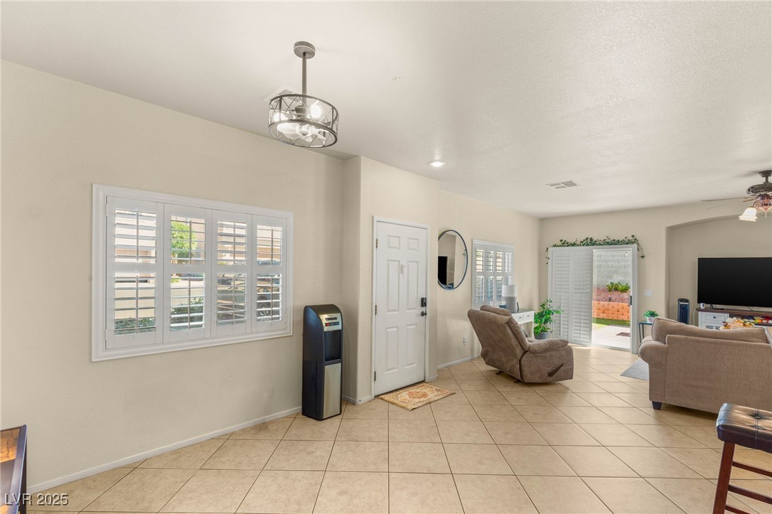 1591 Rusty Ridge Lane Henderson, NV 89002 - Photo 12 of 27 Living area featuring light tile patterned floors and ceiling fan