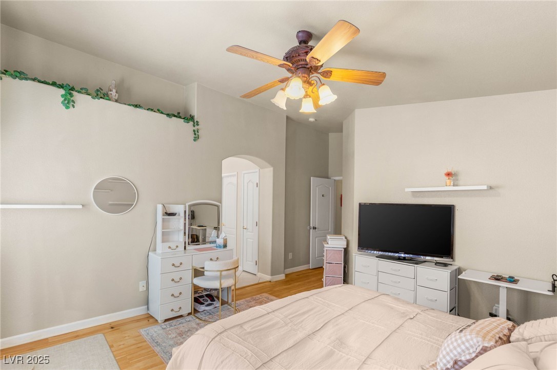 1591 Rusty Ridge Lane Henderson, NV 89002 - Photo 19 of 27 Bedroom with light wood-style flooring, arched walkways, and ceiling fan