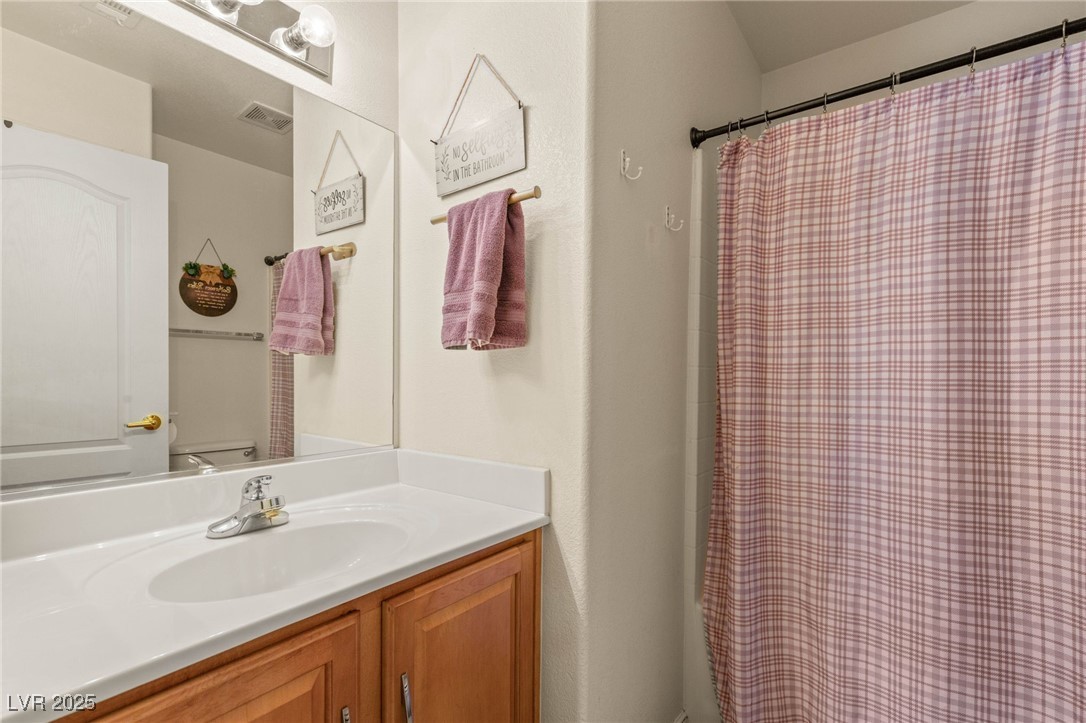 1591 Rusty Ridge Lane Henderson, NV 89002 - Photo 23 of 27 Full bathroom featuring a shower with shower curtain and vanity